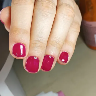 Esmaltado fucsia intenso con un brillo en una uña