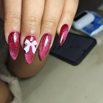 Softgel fucsia con brillo y un lazo en relieve